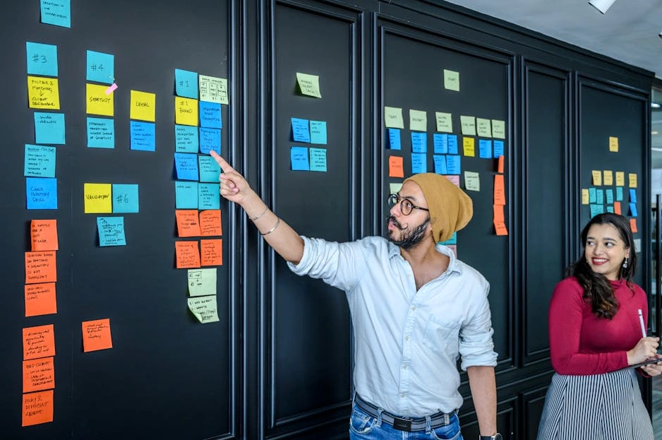 A diverse group of tech professionals brainstorming around a whiteboard in a modern office.